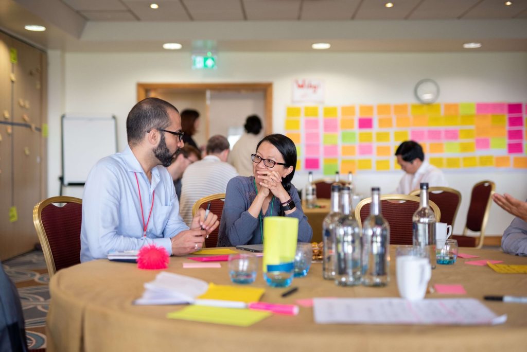 A man and a woman sitting at a table discussing ideas